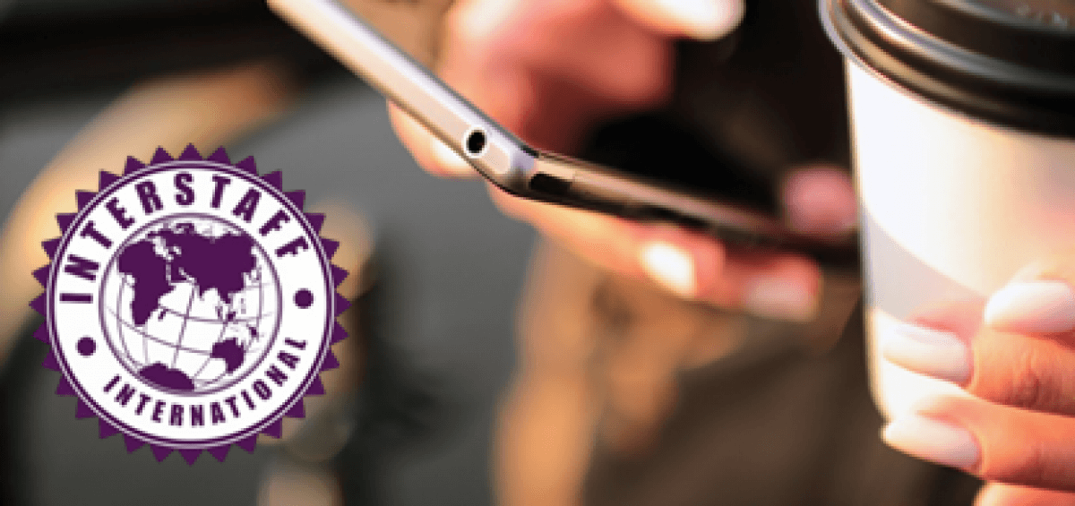 Woman holding her mobile phone and coffee cup with Interstaff International logo