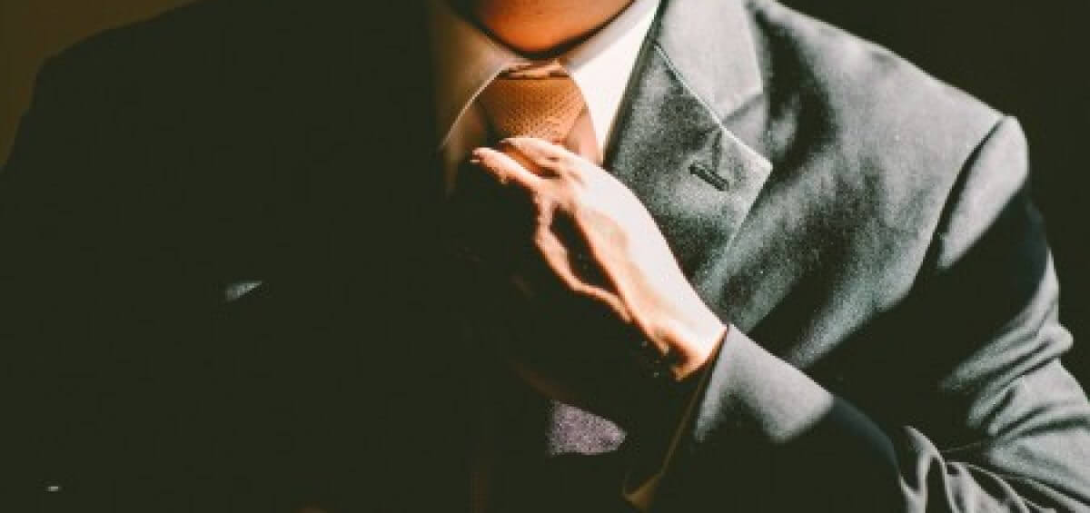Young man fixing up his tie in the morning
