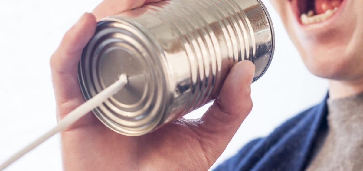 Man talking into tin can to represent marketing amplification