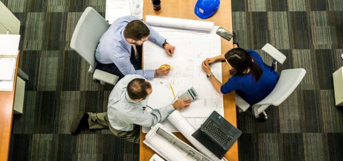 People sitting at business table discussing floor plans
