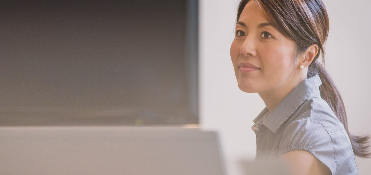 An ethnic woman sitting at her desk looking away