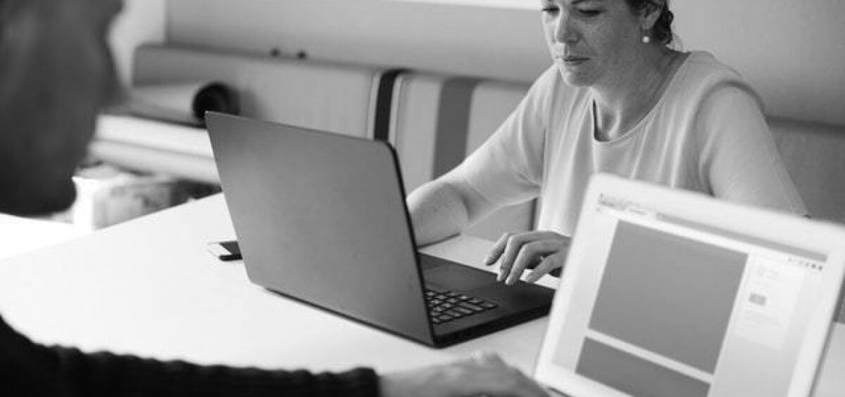 Two people typing on their laptops