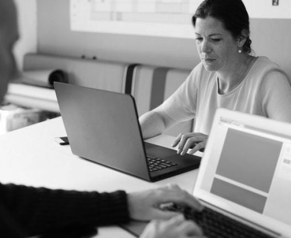 Two people typing on their laptops