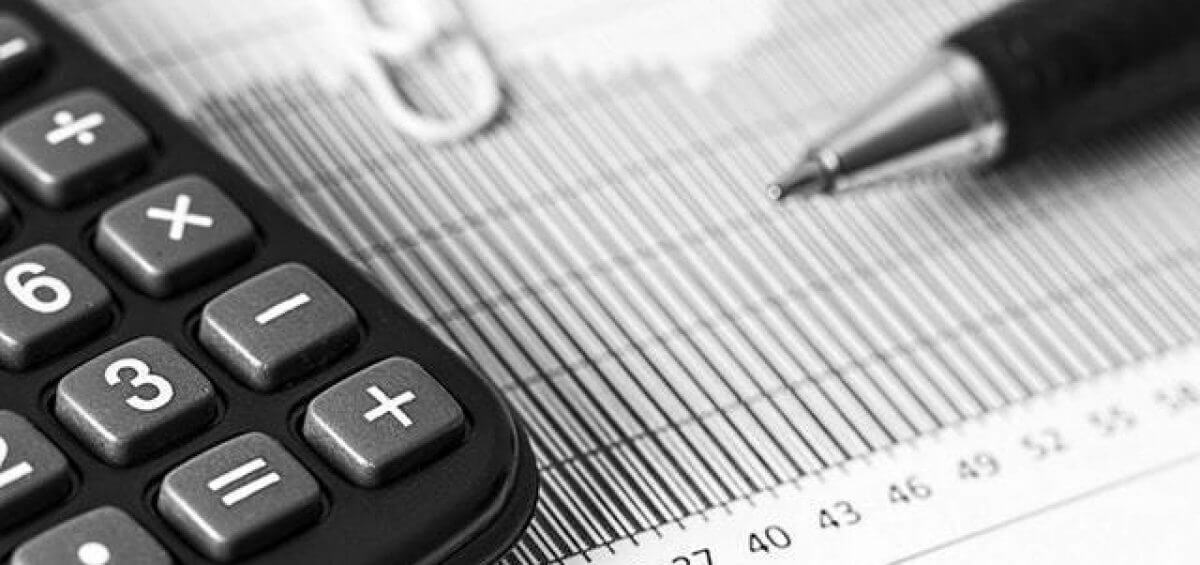 Closeup of a calculator and pen placed on top of a report as SAF refunds are calculated