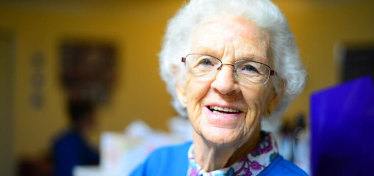 A happy elderly woman smiling over election promises for cheaper and more accessible parent visas