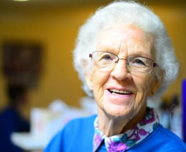 A happy elderly woman smiling over election promises for cheaper and more accessible parent visas