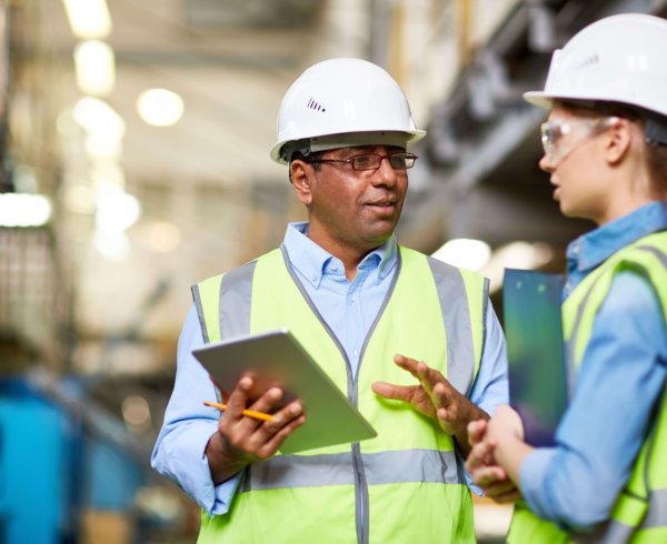 Two high-vis inspectors doing through checklist of work activities