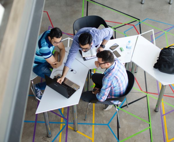 Group of workers discussing the Skilled Occupation List in 2020 in open workspace