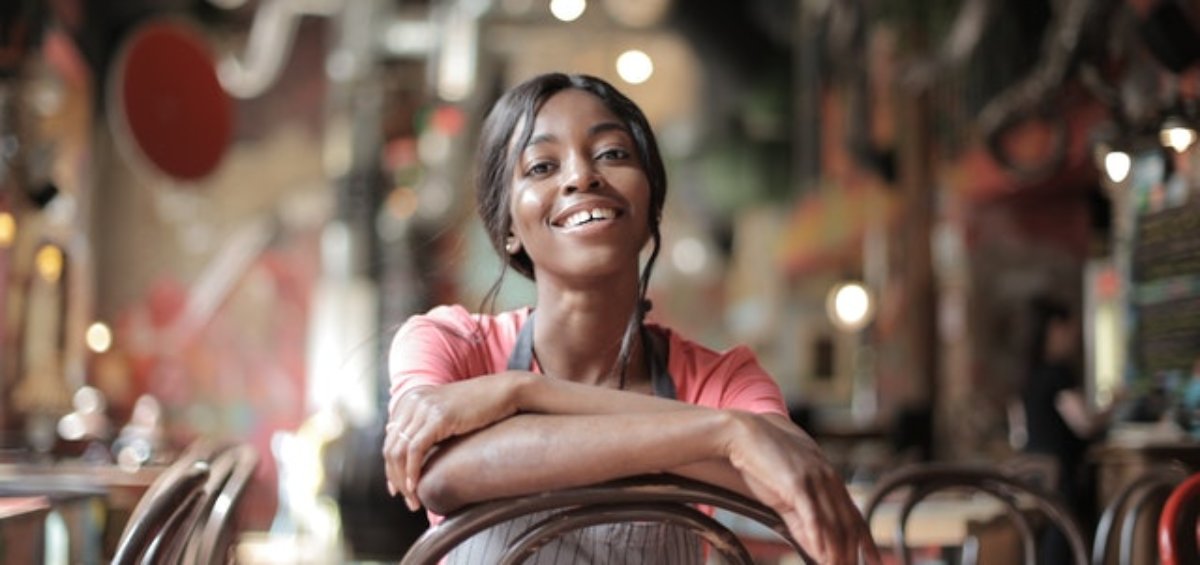 Woman sitting inside of cafe as a Red Cross Visa Holder in Australia