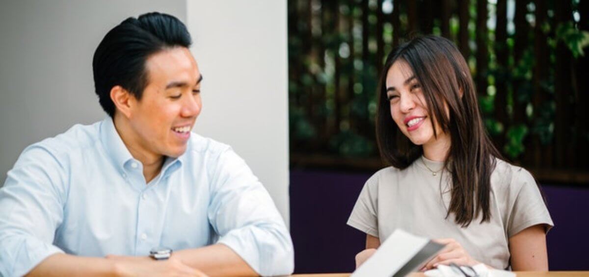 Couple sitting at desk discussing the Australia Government extending visa and PR options for Hong Kong Citizens in Australia